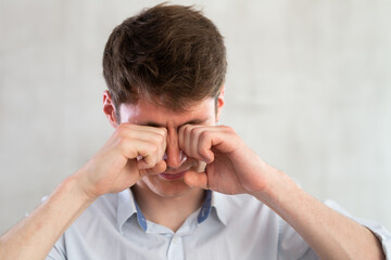 Portrait of young guy with itchy eyes in studio
