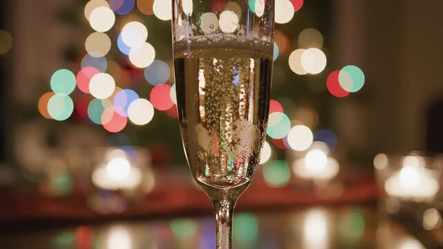 Sparkling champagne flute toast against warm festive bokeh lighting celebrating year end occasion