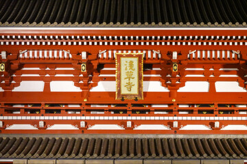 Brightly lit red temple gate glowing at night in Tokyo