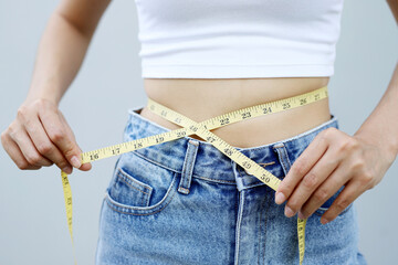 woman want to lose weight taking measurements of her body. and diet measuring waist with measure...