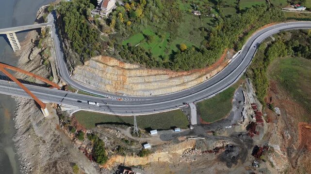 Top-dwon aerial video of Kuk&euml;s showing the A1 Motorway, bridges, lake shoreline, and surrounding hills in warm autumn tones.