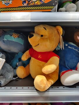 Saintes, France - December 17, 2025: Joue Club. Plush Winnie the Pooh toy sitting on a store shelf among other stuffed animals, showcasing vibrant colors and soft textures in a playful environment