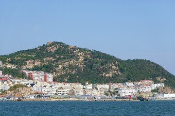 Fototapeta premium Seaside Town And Hill Reflected In Calm Sea
