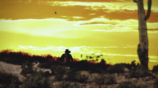 A cowboy in the distance of a western desert landscape sunset scene. Old west gunslinger on the American prairie.