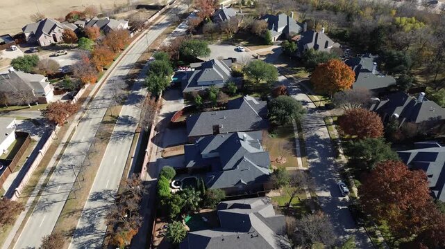 Brick wall and tree-lined median parallel streets separate affluent Coppell homes with spacious lots and backyard pools. Autumn trees and clean sidewalks enhance the quiet suburban atmosphere