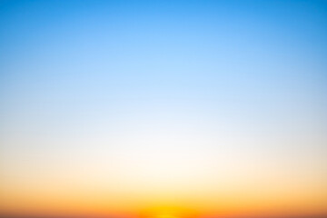 Sunset or sunrise sky with a vibrant gradient of orange, gold, and soft blue. Clear atmosphere with wispy clouds. Peaceful, natural light background. hope, freedom, new day and inspirational Concepts
