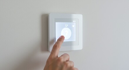 A hand adjusts a modern smart thermostat, highlighting the concept of home automation.Concept of climate control and home automation.
