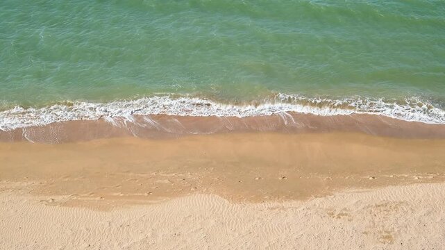 sea surf on sandy beach, slow motion, top view
