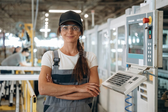 Modern window making factory, woman in professional uniform is standing