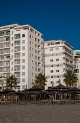 A modern seaside residential complex near a sandy beach.