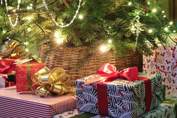 Festive wrapped gift with red ribbon under Christmas tree lights