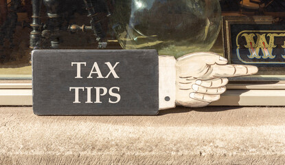 Tax tips symbol. Concept word Tax tips on beautiful black wooden hand with finger. Beautiful shop display background. Business tax tips concept. Copy space.