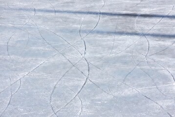 Skating marks on frozen ice surface in winter daylight
