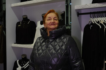 A woman tries on a jacket in a clothing store. High quality photo