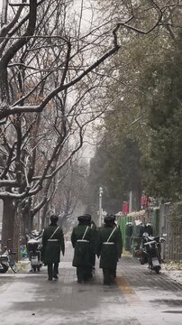 Chinese soldiers walking in snow, Beijing, China.