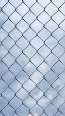 Fototapeta premium A close-up view of a metallic chain-link fence with a soft sky background creating a serene effect