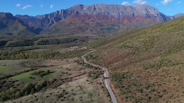 The mountain road near Llugaj opens into the Bajram Curri valley, framed by autumn fields and the Albanian Alps.