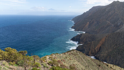 Fototapeta premium Rauhe Küste mit Klippen auf der Kanareninsel La Gomera, mit dem Vulkan Teide auf Teneriffa im Hintergrund