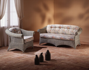 Single shot photo of a room with a wicker sofa and armchair