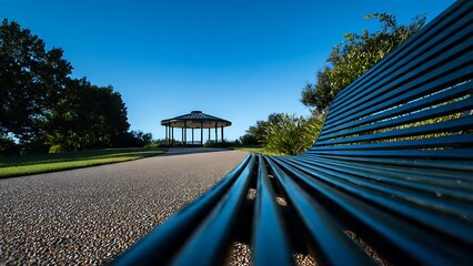 Leading Line Perspective Shot of a Curved Blue Bench in a Tranquil Park Setting