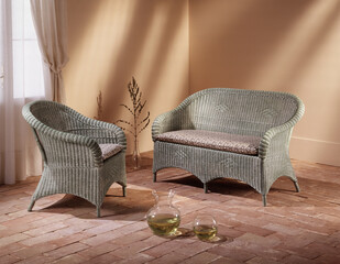 Single shot photo of a room with a wicker sofa and armchair