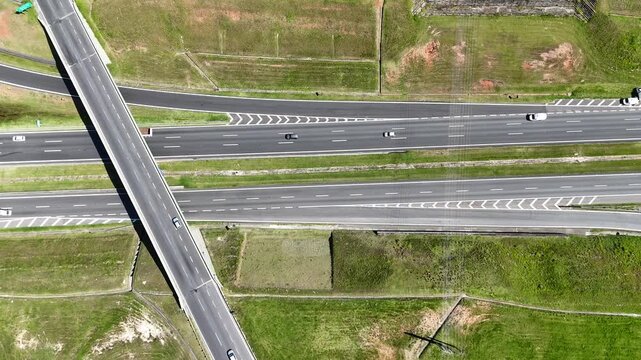 Vis&atilde;o a&eacute;rea de rodovia com tr&aacute;fego de ve&iacute;culos em &aacute;rea urbana, destacando fluxo vi&aacute;rio, mobilidade e infraestrutura de transporte.