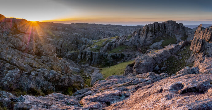 Panoramic sunset over Los Gigantes mountain range in Cordoba, Argentina. Golden sunlight hitting granite rock formations and rugged landscape during golden hour. - Powered by Adobe