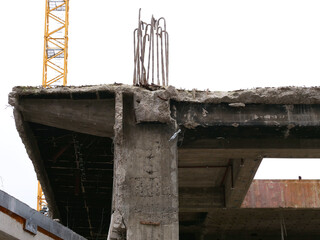 Demolition work on a construction site with concrete pillars, steel beams, etc.