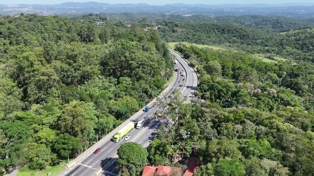 Rodovia em &aacute;rea de serra na regi&atilde;o de Mogi das Cruzes com destino ao litoral, destacando transporte, natureza preservada e infraestrutura rodovi&aacute;ria regional