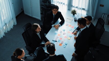 Top view of diverse team clapping hand and applause to celebrate for getting promotion at meeting room. Successful team shaking hand to congratulate successful project at meeting table. Directorate.