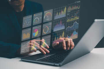 A person interacts with a laptop displaying holographic graphs and charts, showcasing data analysis and digital insights.