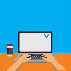 Hands in work at laptop keyboard with blank monitor screen at table. Workplace with a glass of coffee