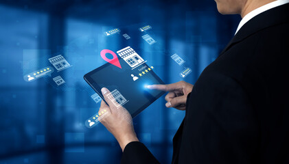 A businessman interacts with a tablet displaying location icons and business data. The modern office backdrop emphasizes the importance of technology in business growth and analytics. Gantry