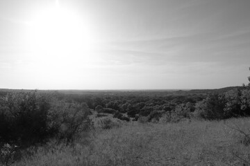 Rural countryside Texas landscape shows expansive view of hills in black and white.