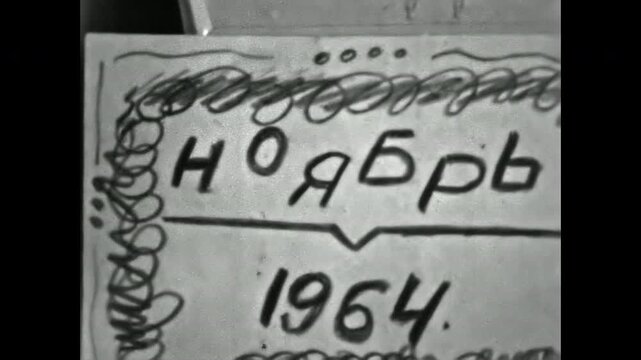 Close up, handwritten date November 1964 in Cyrillic alphabet on home movie film leader. Damaged, grainy, flickering black and white archival footage. Old film. Archival retro 1960s. Vintage archive