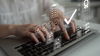 A close-up view of hands typing on a laptop keyboard surrounded by digital icons and checkmarks,...