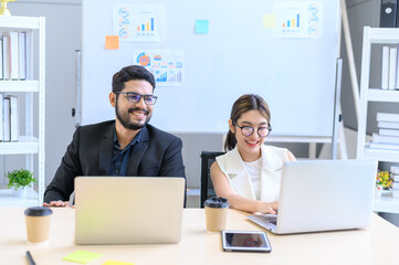 Business people working together with laptop computers on the desk in the office, businesswoman and businessman checking documents on laptop computer.