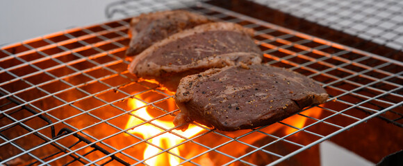 Grilled beef steak cooking on a charcoal fire. BBQ moments that bring people together.