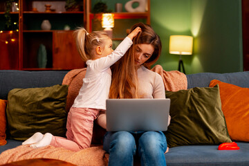 Mother experiencing burnout while working from home, child distracting her