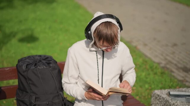 hoodie reader flipping pages on bench novelist editing draft, manga fan scanning panels, language student practicing vocabulary, traveler journaling routes, musician pausing to listen topdown