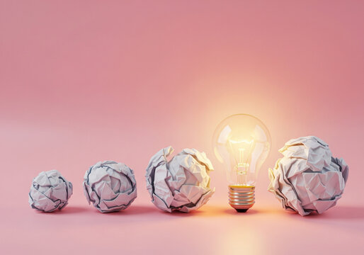 Brainstorming process: Crumpled paper balls leading to a bright idea light bulb