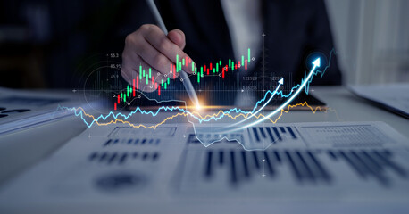 A businessman uses a pen to analyze stock market data and financial trends with graphs and charts in a modern office environment, showcasing strategic growth and investment insights. Scalp