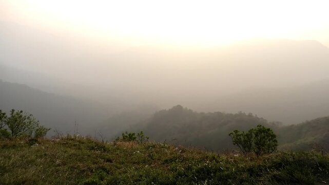 The panoramic landscape of Parunthumpara, Idukki, Kerala, India covered in heavy fog at dusk