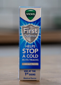 Vicks. Cold relief spray packaging on a wooden table with blurred background.