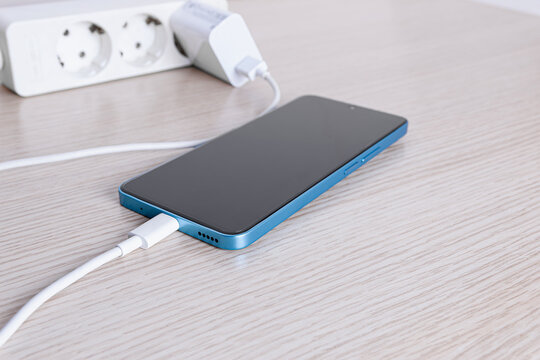 Smartphone charging with power strip and adapter. - Powered by Adobe