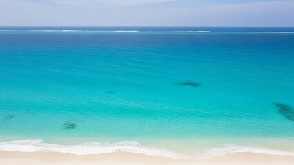 Tranquil turquoise ocean with sandy beach under clear blue sky  