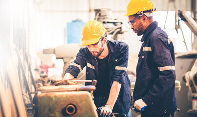 Portrait of Heavy industry workers working on the metal fabrication process by operating a lathe at a machine for steel structure industry.