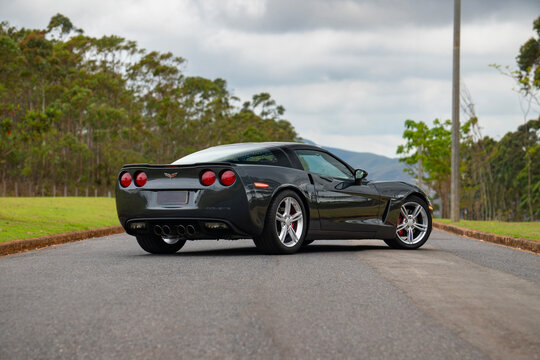 Gray Chevrolet Corvette C6 rear three quarter view, American muscle car on asphalt road