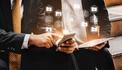 Two business professionals collaborate using digital devices, highlighting cloud computing and data analysis with floating icons representing security and technology advancements. Gantry