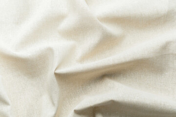 Fototapeta premium Natural beige fabric textile with soft folds and texture close up